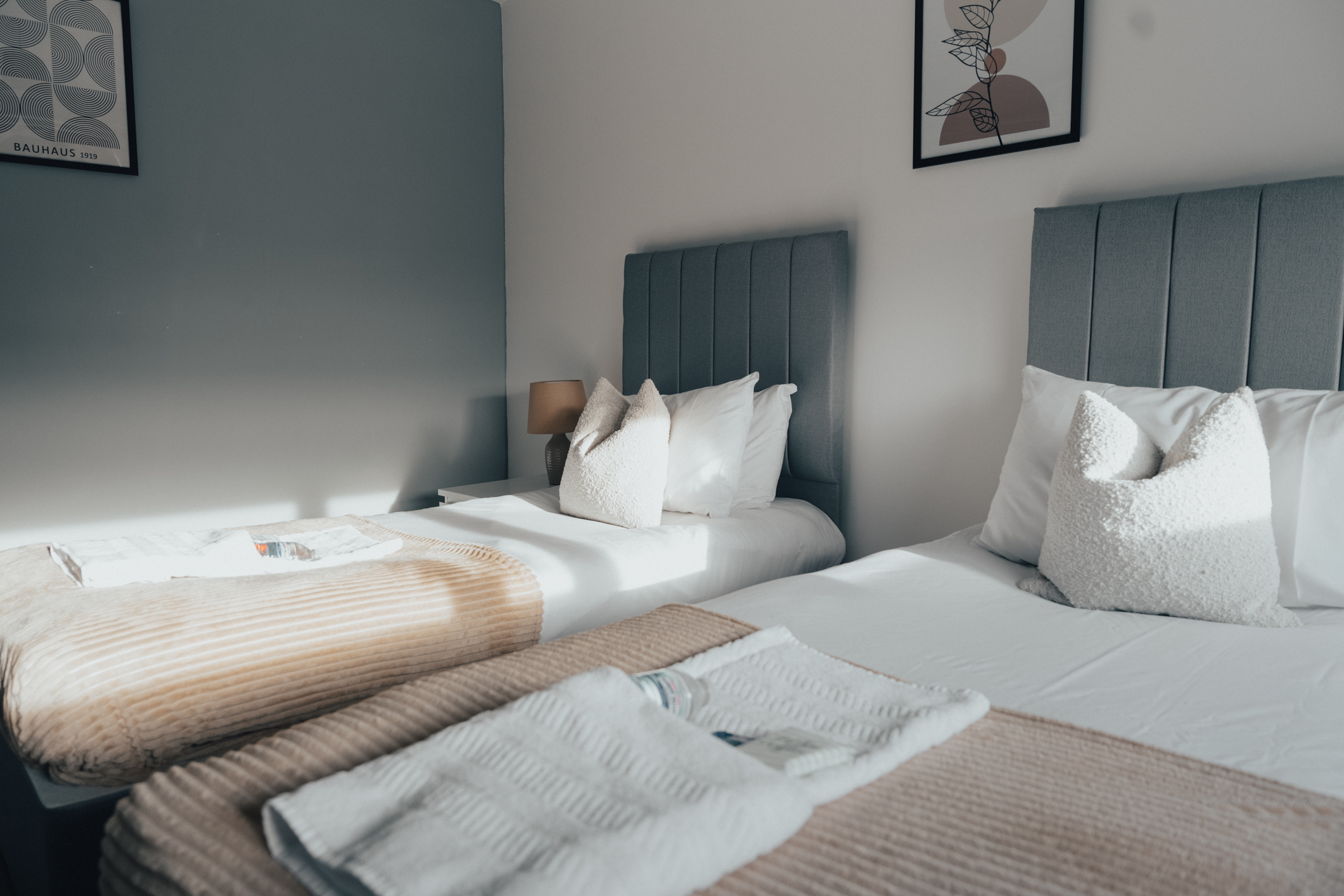 Twin beds made up with fresh linen and towels folded at the foot of each